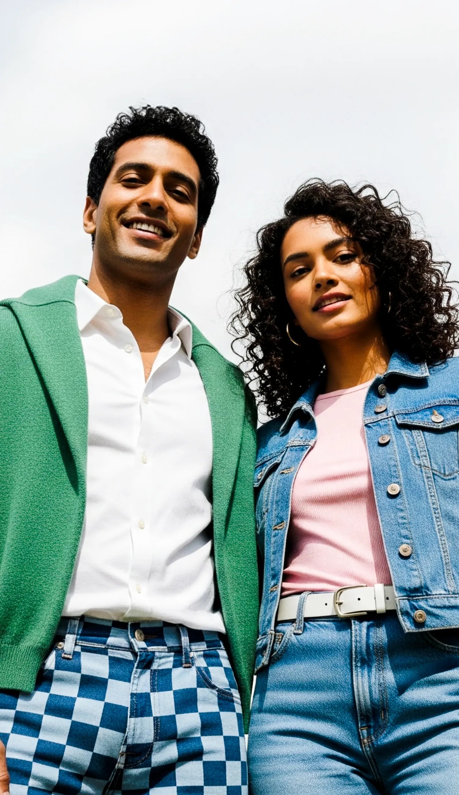 Two people standing close together against a light background